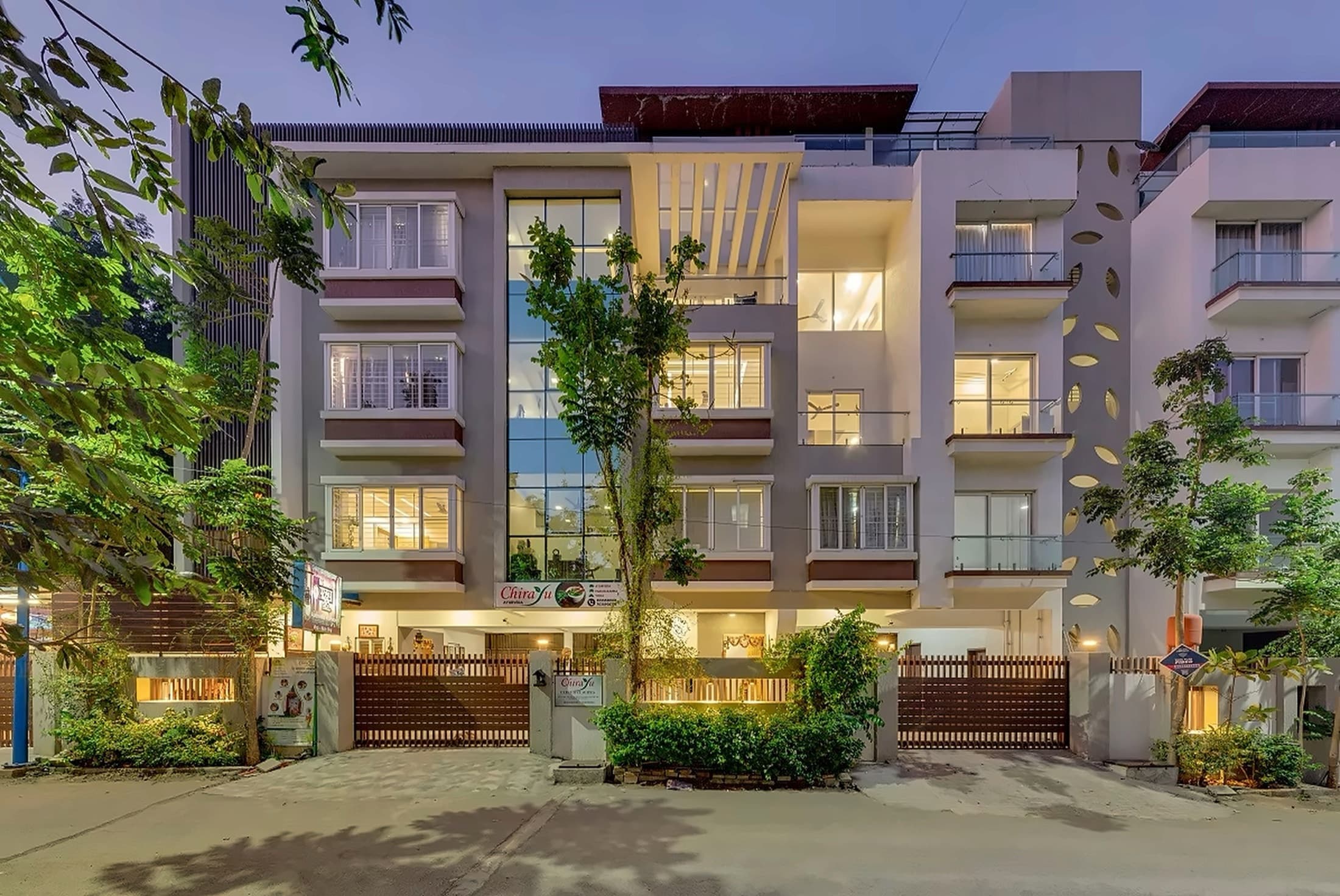 The three-villa Chirayu Executive Suites property illuminated at dusk